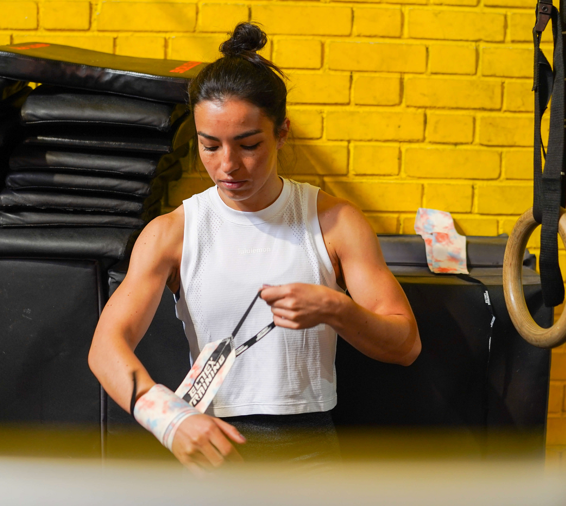 Athlete putting on Elitex fabric wrist wraps at the gym