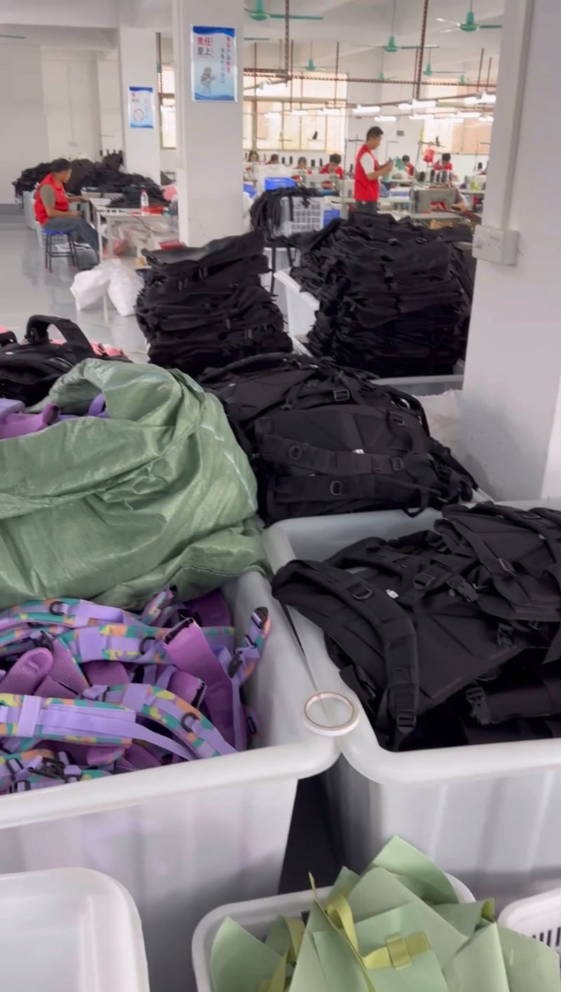 Mochilas en proceso de fabricación y personas trabajando en la zona de producción